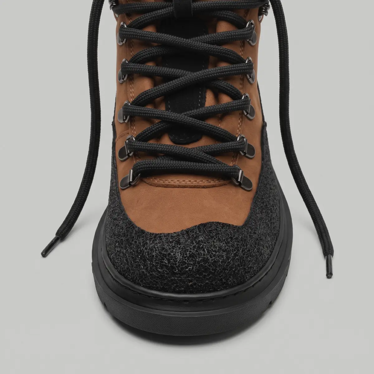 Front view of a men's Armor-24 boot on white: brown upper, black laces on metal hooks and a chunky black sole