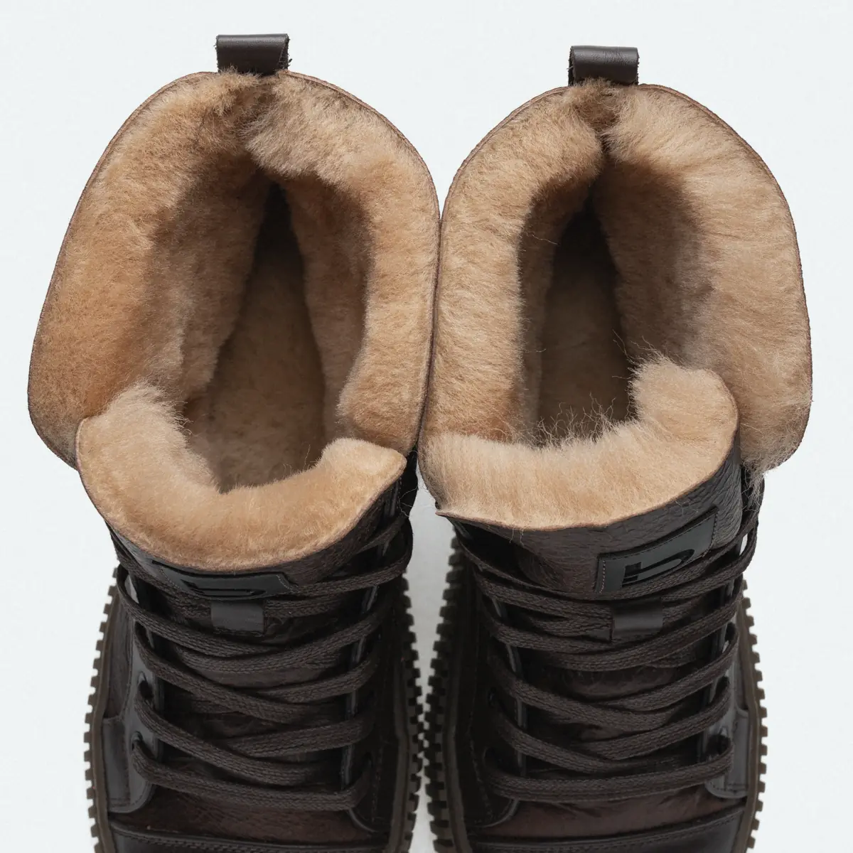 Dark brown men's Frost-84 sheepskin boots seen from above, showing the thick light sheepskin fleece inside and the laces