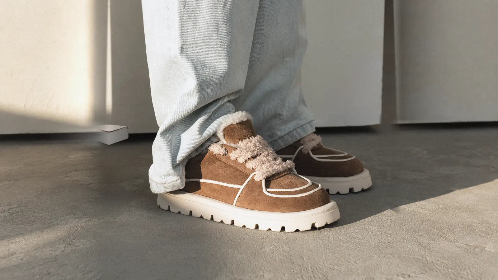 Tan suede Babylon sneakers with fur trim and wide light jeans