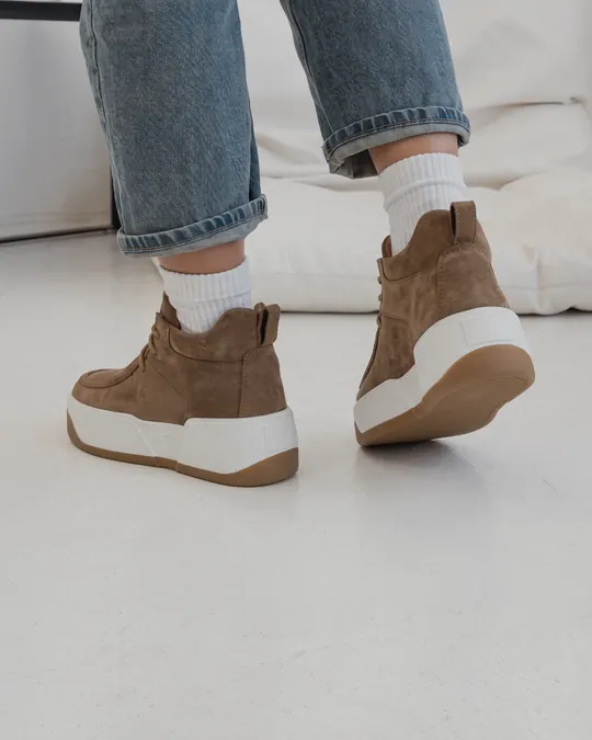 Feet in jeans and white socks wearing brown nubuck Babylon Verona-94 boots on a white sole