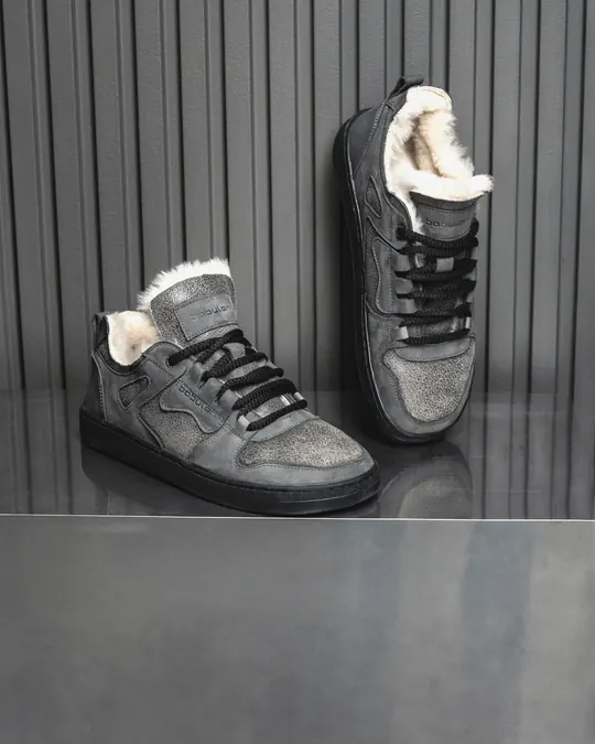 A pair of grey fur-lined Babylon Space-02-D sneakers on a metal shelf against dark panelling